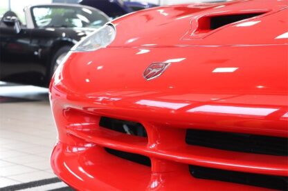 The front end of a red sports car in a showroom.