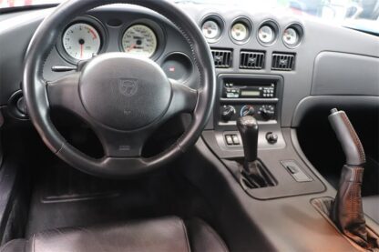 The dashboard and steering wheel of a black sports car.