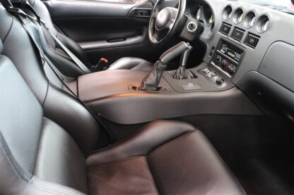 The interior of a sports car with leather seats and steering wheel.
