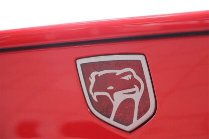 The emblem of a red car with a bear on it.
