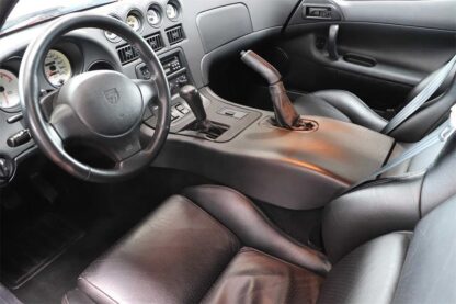The interior of a sports car with leather seats and steering wheel.