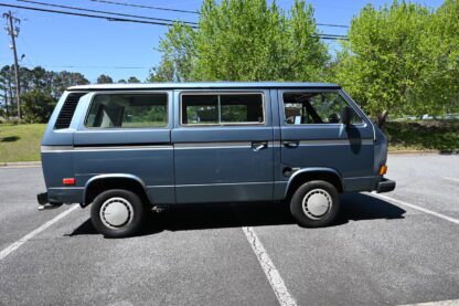 A blue volkswagen bus parked in a parking lot.