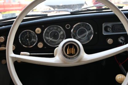 The steering wheel and dashboard of a classic car.