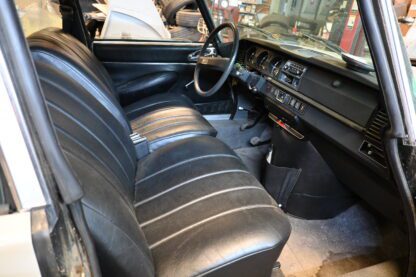The interior of a car with leather seats and a steering wheel.