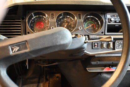 The dashboard of a car with a steering wheel and gauges.
